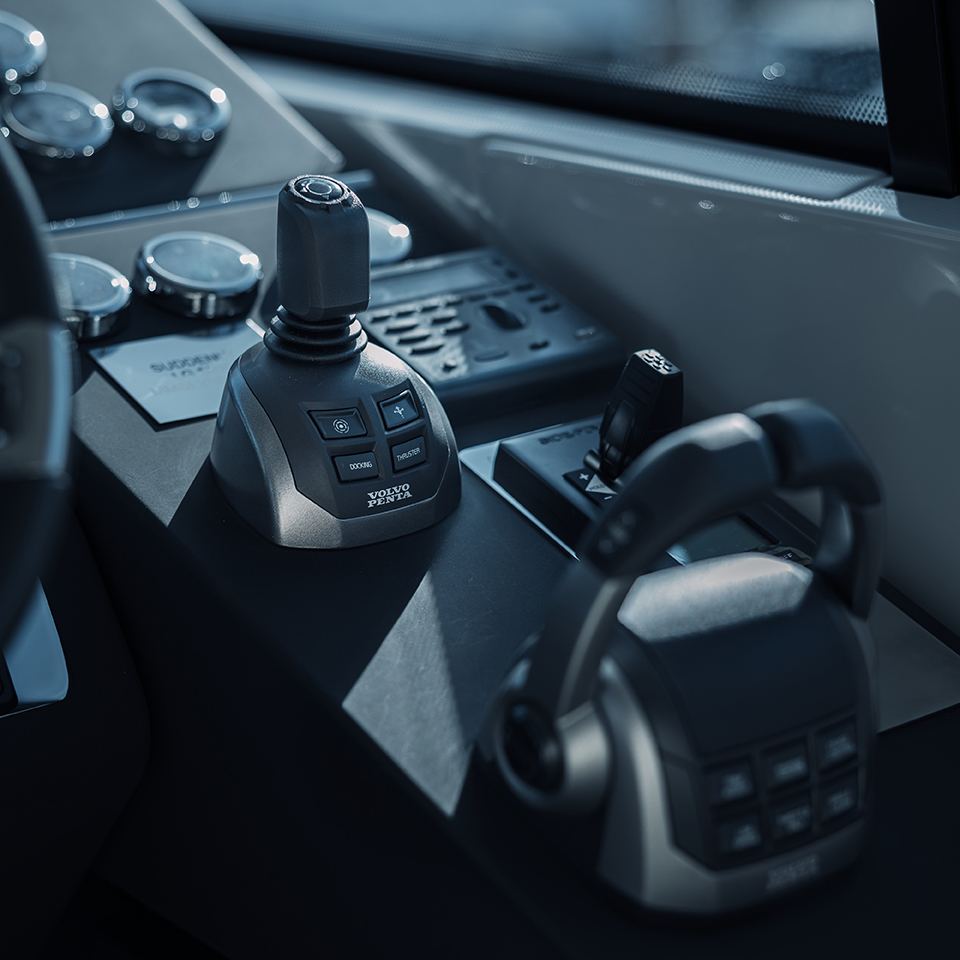 A boat helm with a Volvo Penta docking joystick, an electronic control lever and instrument gauges